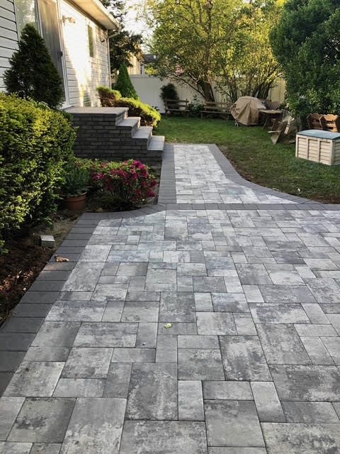 Paver patio and walkway with planting beds along the house