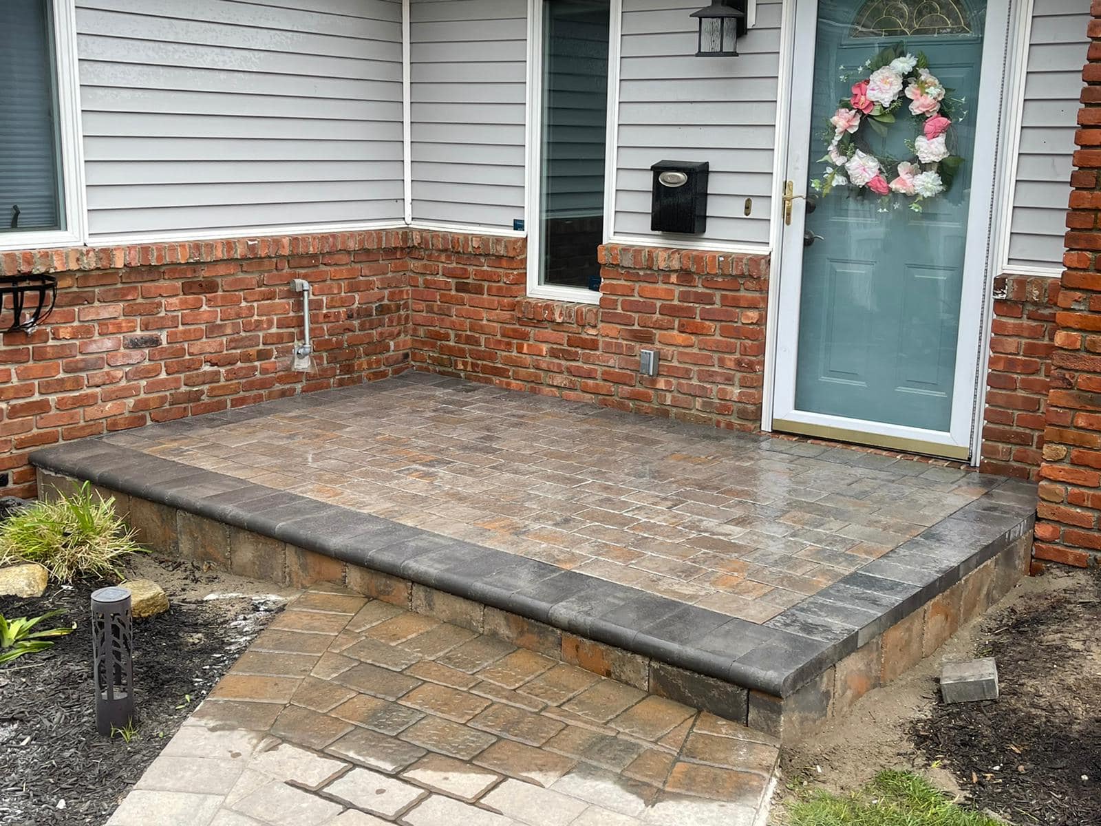Stoop with cultured stone veneer riser wall