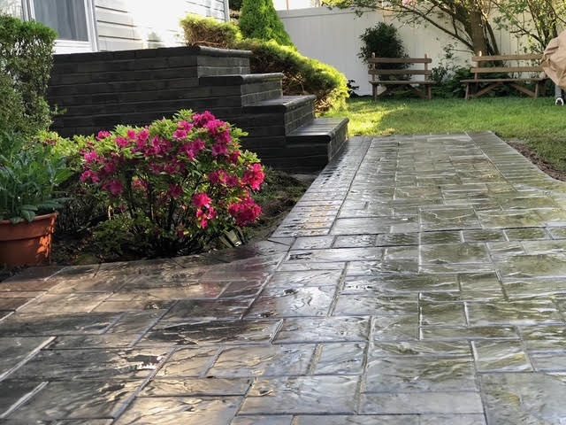 Stamped concrete patio with dark block steps and azaleas