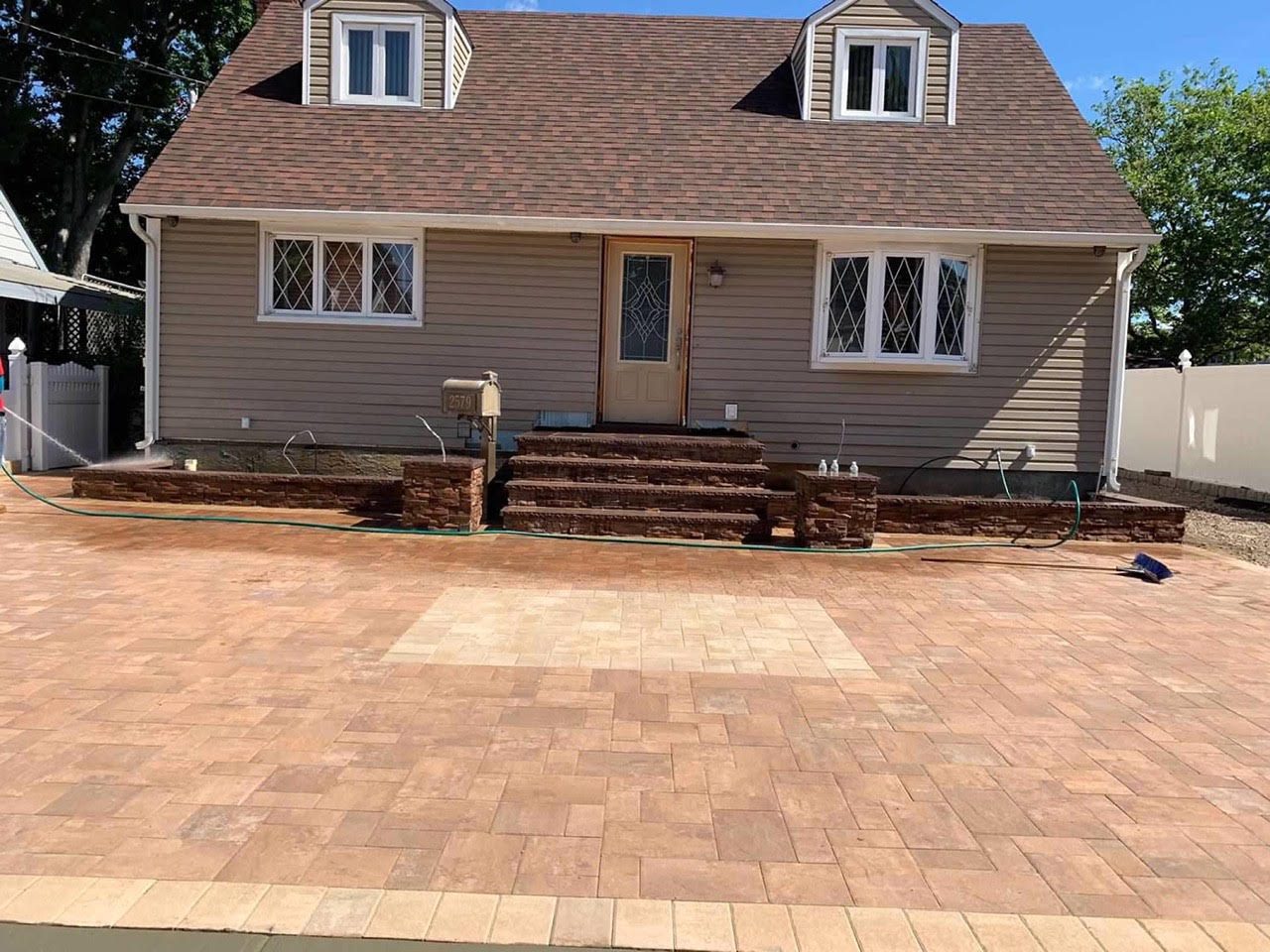 Paver front courtyard and parking area at a cape home