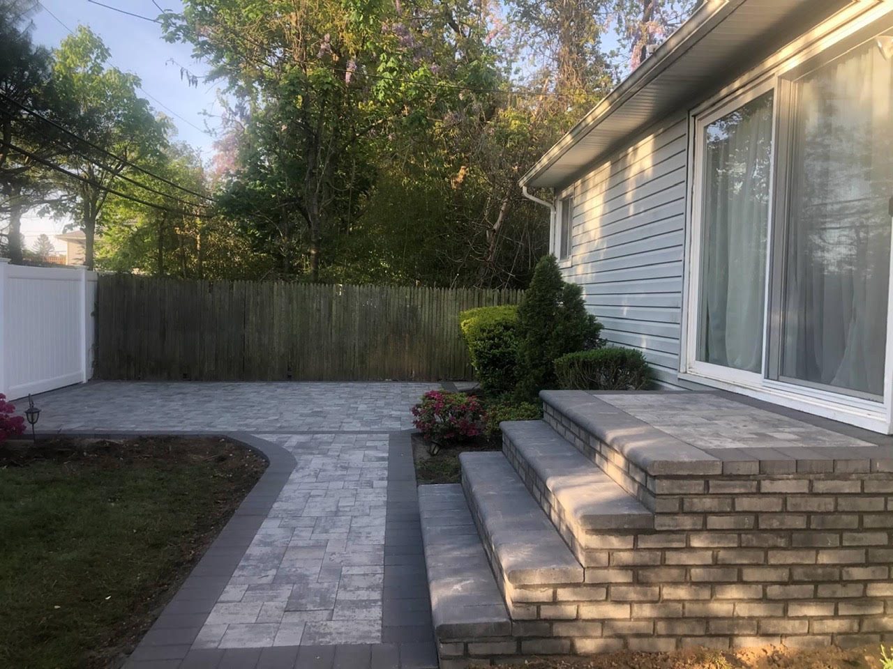 Backyard paver patio with brick steps and paver walkway