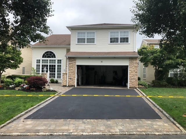 New asphalt driveway with decorative paver entry