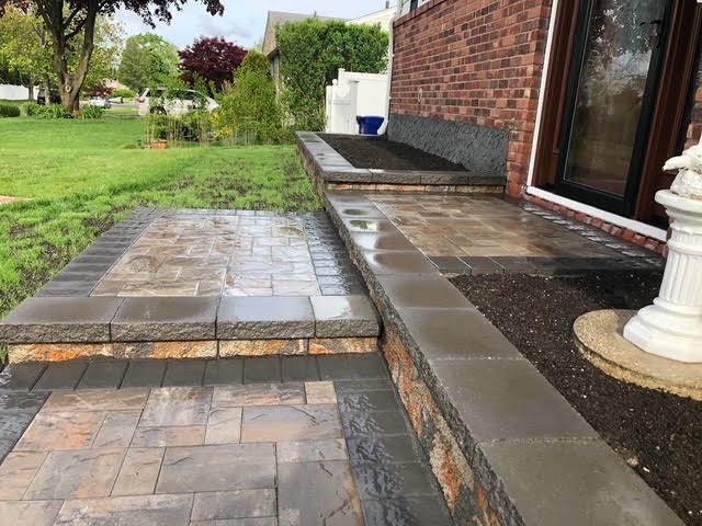 Stone front stoop and walkway at a brick Long Island home